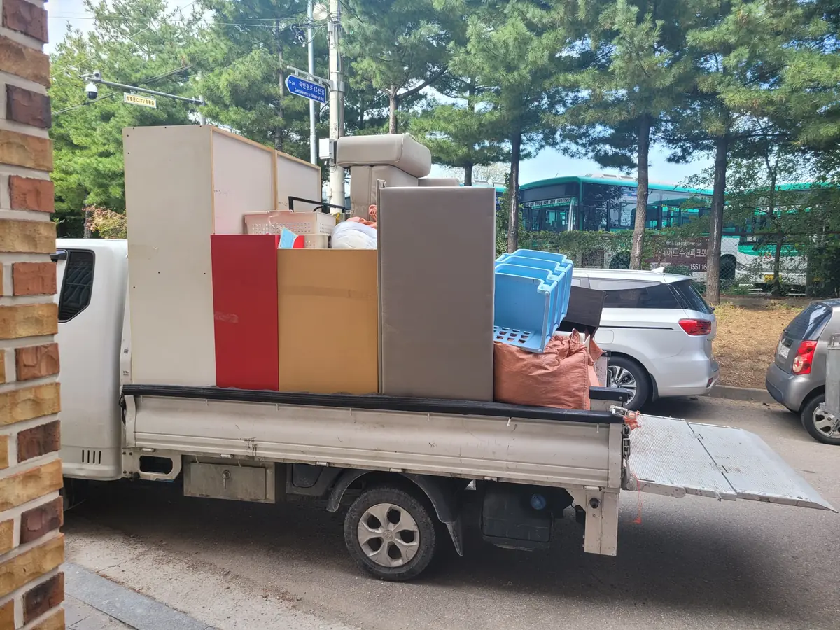 트럭 적재함에 장롱과 가구, 포대를 실은 폐가구수거 차량