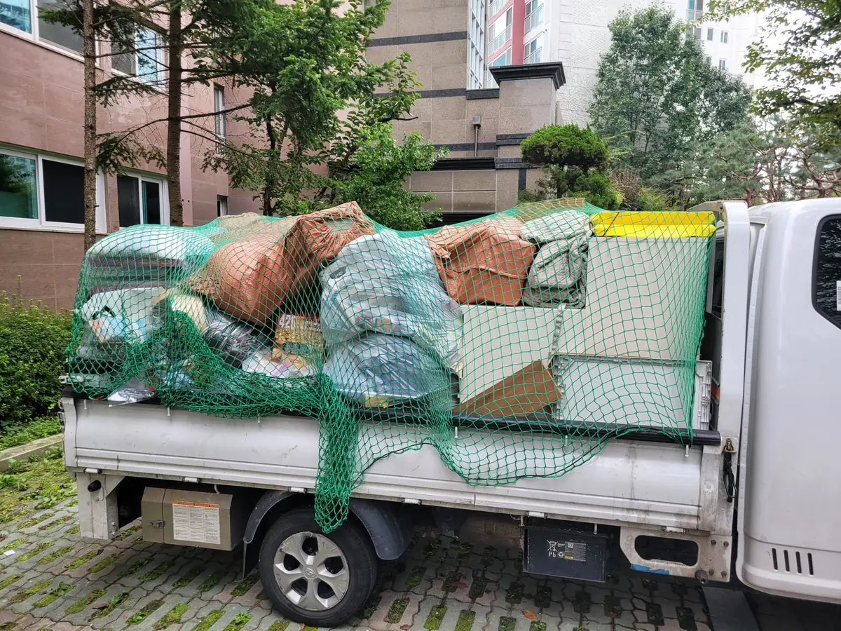 수거한 가구와 짐을 그물로 덮어 실은 트럭